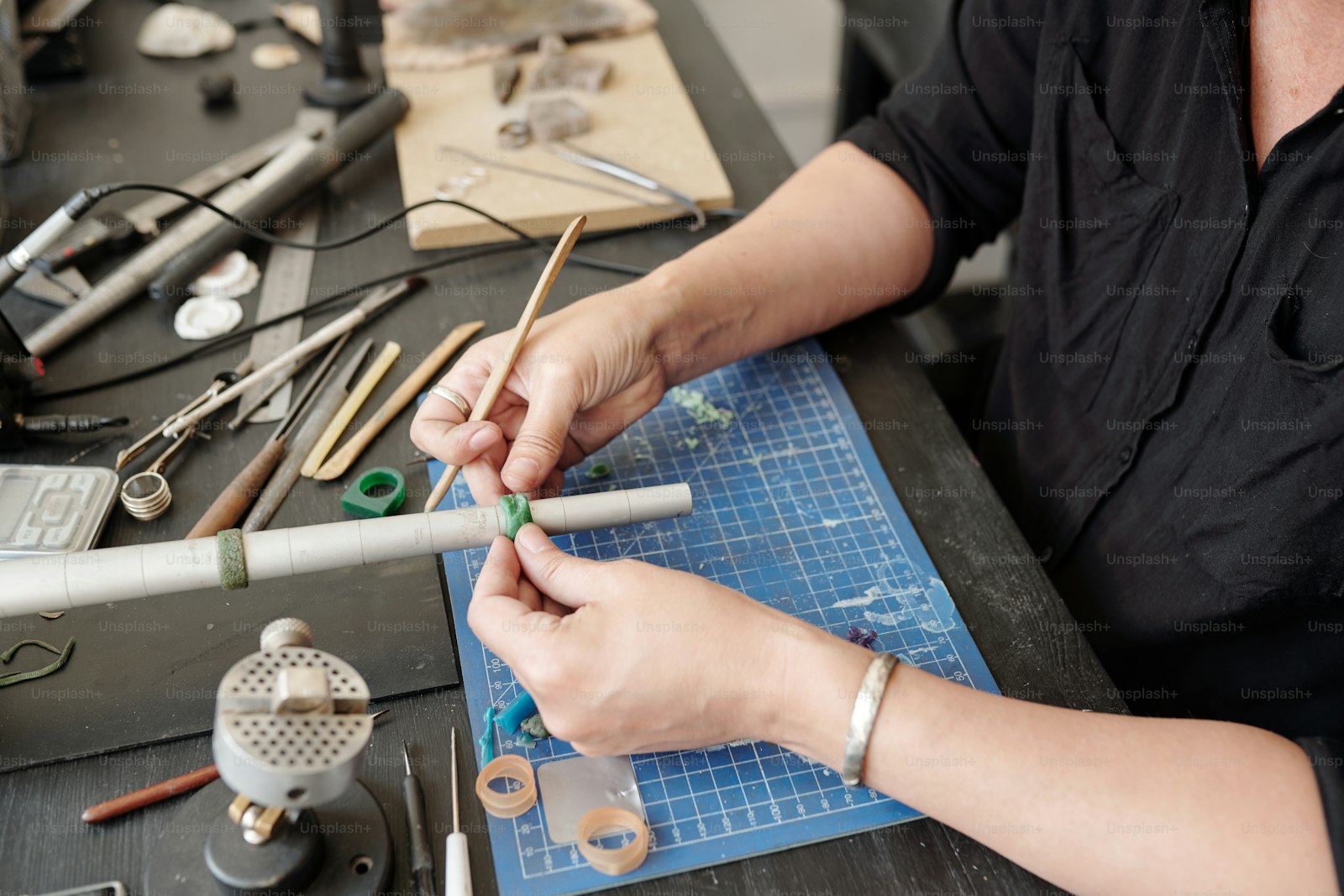 Jeweler at the bench checking a ring against a sizer — in-house sizing and repair at Kingman Turquoise & Jewelry